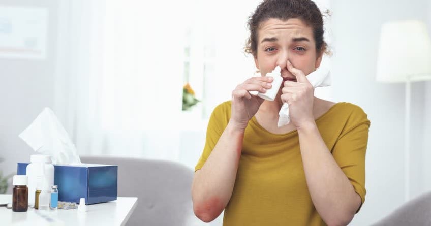 Donna con allergia che spruzza spray nasale