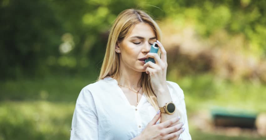 Donna che usa brondilatatore per asma