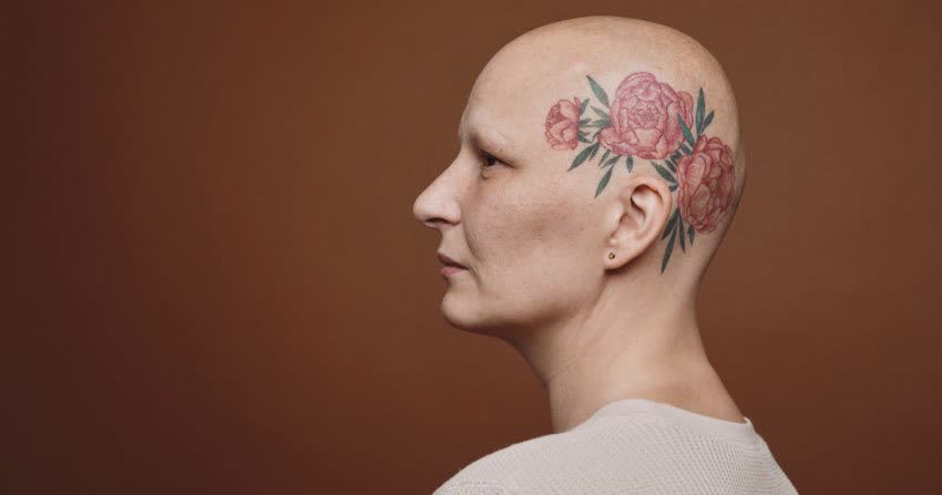 Donna glabra con tatuaggio floreare sulla testa