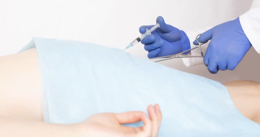 Close up su mani di un medico chirurgo durante intervento per emorroidi