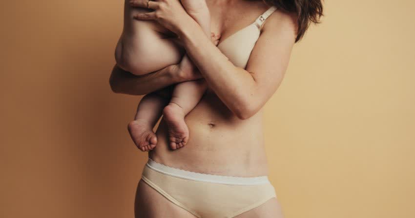 Figura femminile post parto con in braccio un neonato