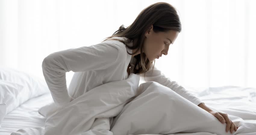 Donna a letto con dolore diffuso fibromialgia