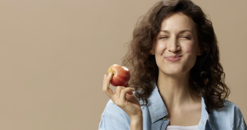 Donna che mastica una mela lentamente