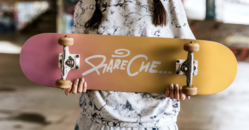 Giovane donna con skateboard con la scritta RareChe