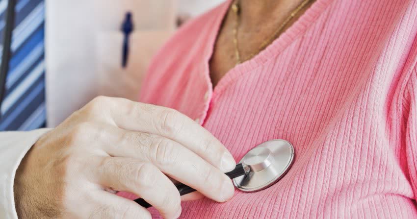 Medico che ascolta il battito cardiaco di una donna anziana