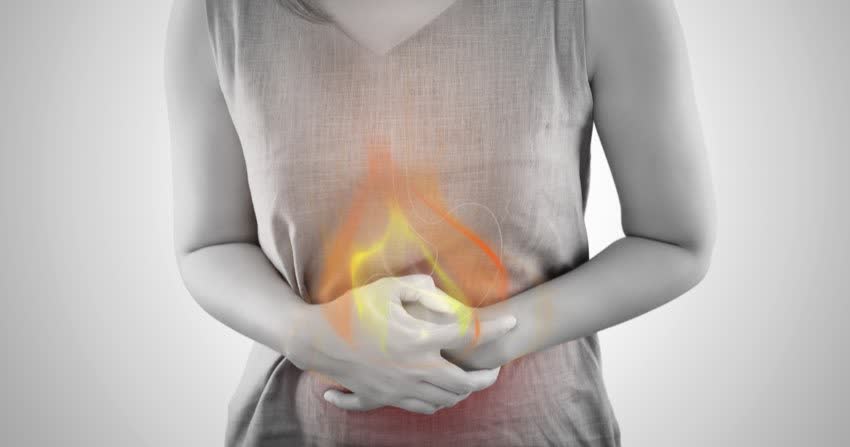 Donna con immagine di fiamma sullo stomaco ad indicare presenza di un'ulcera