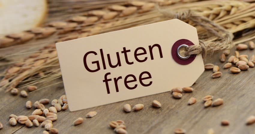 Cartellino con scritta Gluten Free su sfondo di spighe di grano