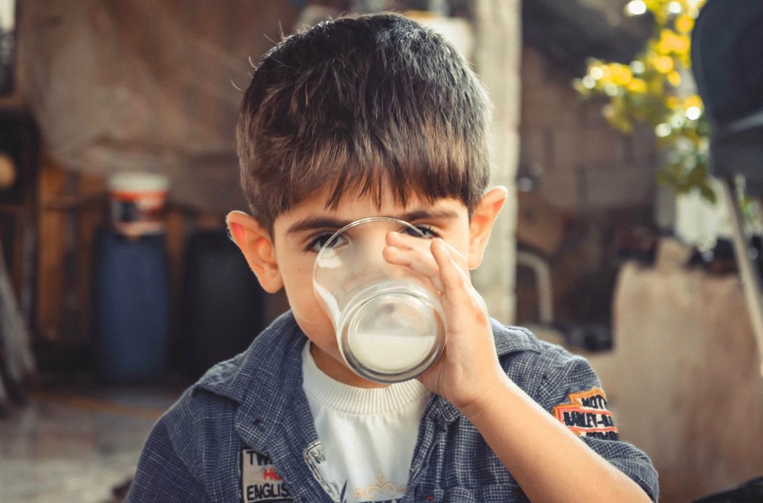 Bambino beve latte con vitamina D