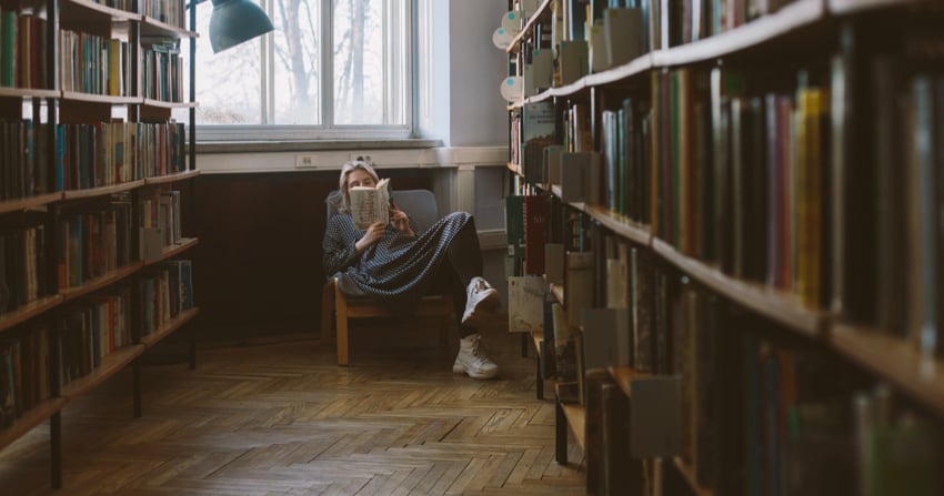 Persona intenta in lettura in biblioteca