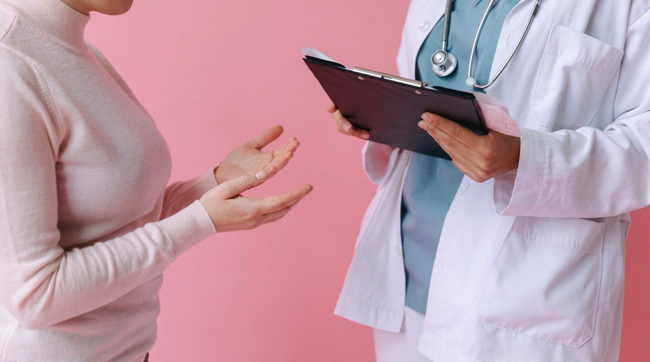 Fotografia di una paziente donna mentre parla con un medico riguardo ai sintomi del tumore al seno