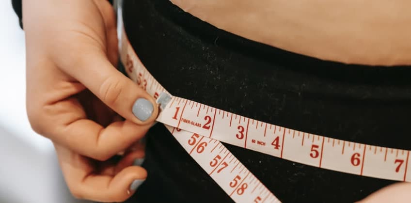 Foto di donna che si misura la circonferenza a rappresentare il bypass gastrico