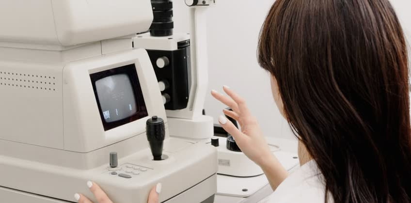 medico oculista alle prese con macchinario per rilevazione glaucoma